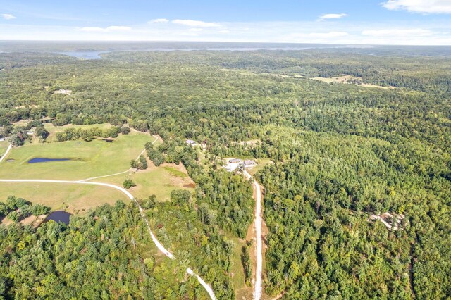 drone / aerial view featuring a wooded view