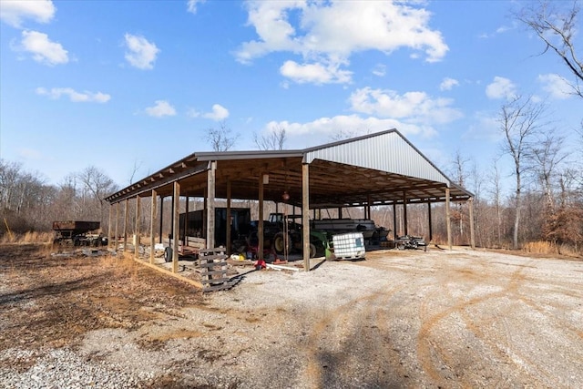 view of vehicle parking featuring a detached carport and dirt driveway