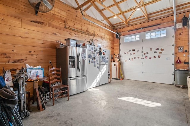 garage with stainless steel fridge and wooden walls