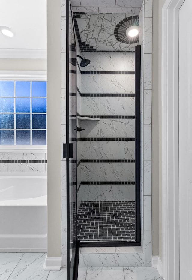 full bathroom featuring baseboards, marble finish floor, a garden tub, and a shower stall