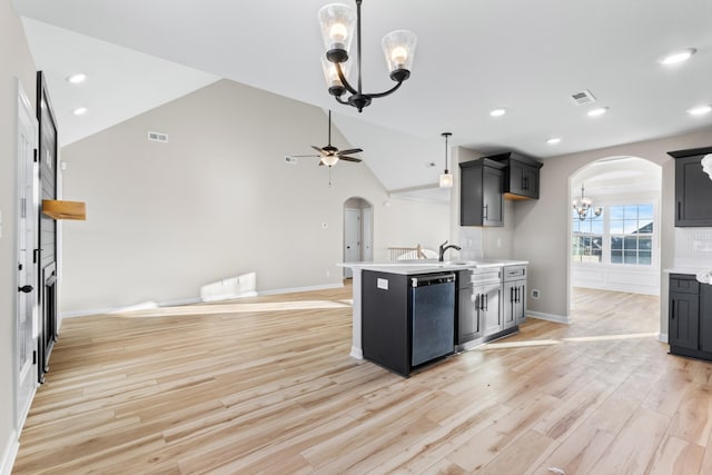 kitchen featuring arched walkways, lofted ceiling, ceiling fan with notable chandelier, light countertops, and dishwasher