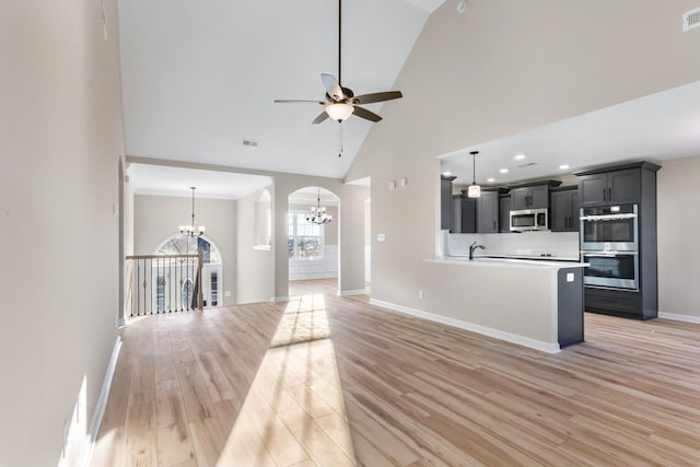 kitchen with visible vents, stainless steel appliances, high vaulted ceiling, and light wood-style flooring