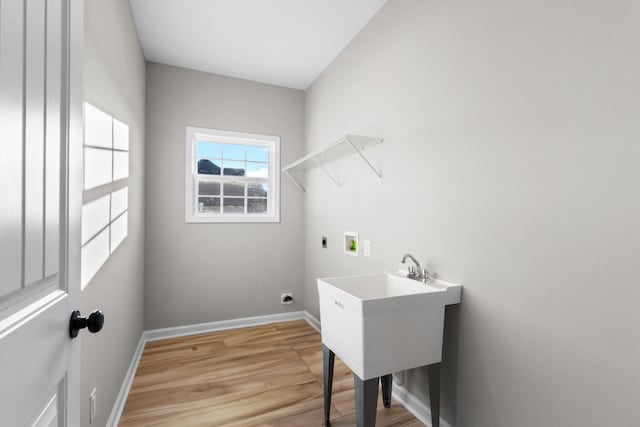 washroom featuring light wood finished floors, hookup for a washing machine, electric dryer hookup, laundry area, and baseboards