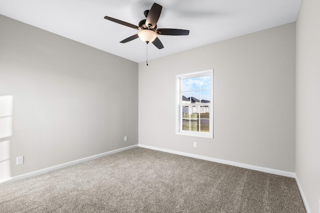 spare room featuring ceiling fan, carpet floors, and baseboards