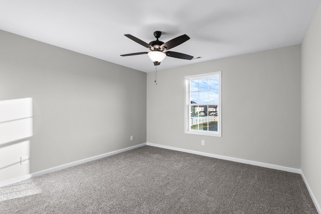 carpeted empty room with a ceiling fan and baseboards