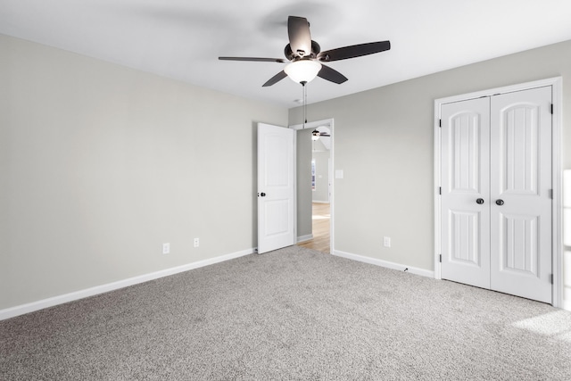 unfurnished bedroom with carpet floors, a closet, a ceiling fan, and baseboards