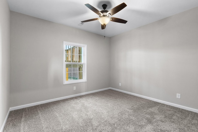 carpeted empty room with baseboards and a ceiling fan