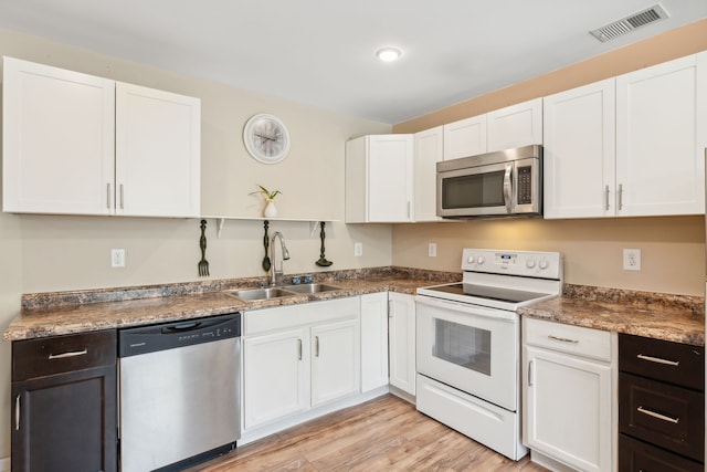 kitchen featuring light wood-type flooring, white cabinets, stainless steel appliances, and sink