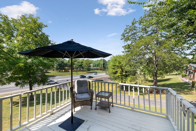 wooden terrace featuring a lawn