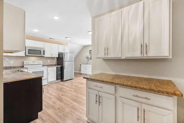 kitchen with light wood-type flooring, sink, appliances with stainless steel finishes, and light stone countertops