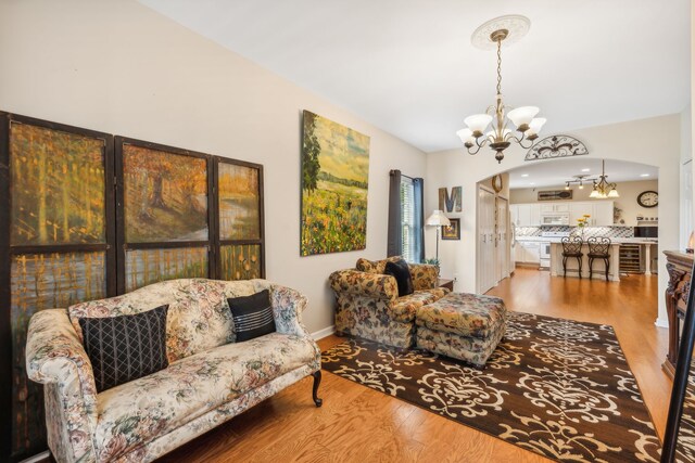 living room featuring wood-type flooring and an inviting chandelier