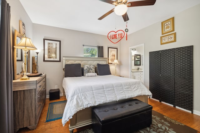 bedroom featuring ceiling fan, dark hardwood / wood-style floors, and connected bathroom