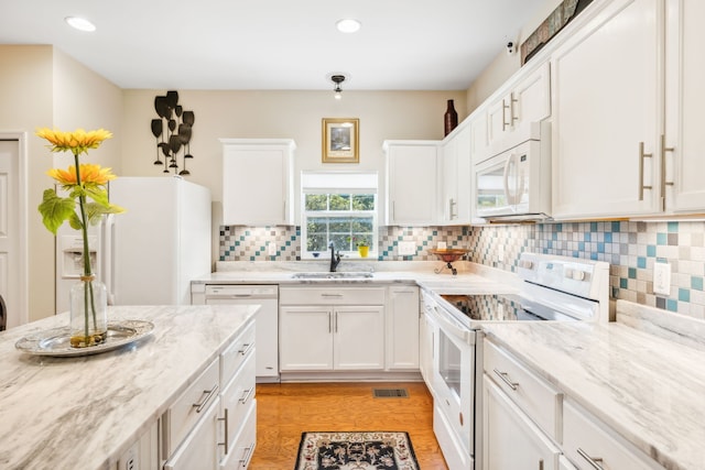 kitchen featuring white cabinetry, white appliances, and light hardwood / wood-style flooring