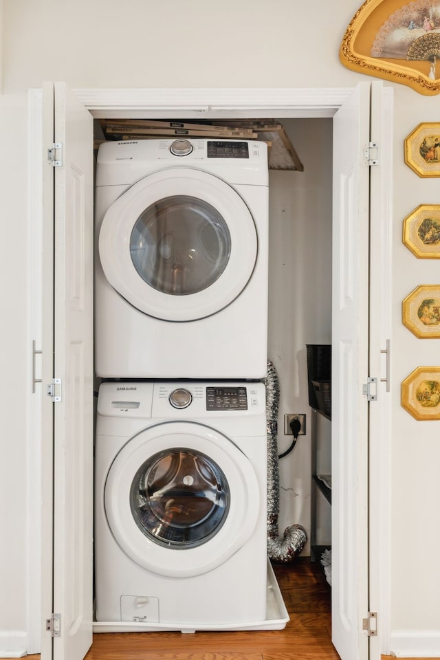 laundry area featuring hardwood / wood-style flooring and stacked washer / dryer