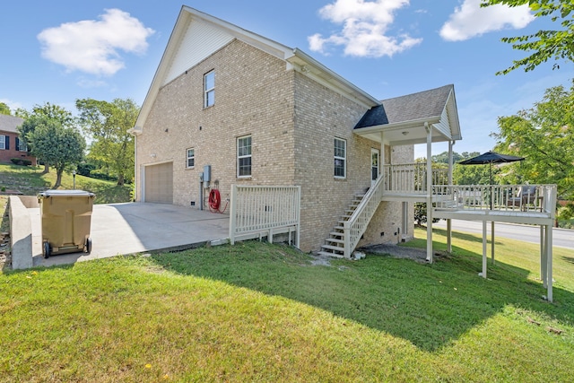 view of side of property with a yard, a wooden deck, and a garage