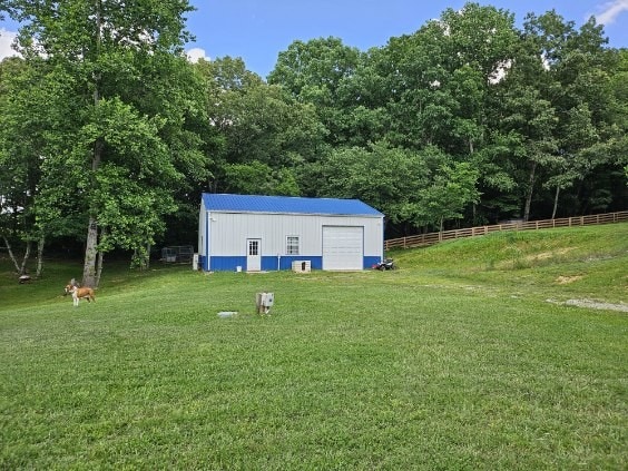 view of outbuilding with a lawn, a rural view, and a garage