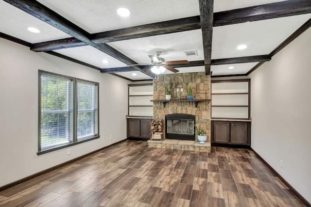 unfurnished living room with coffered ceiling, beamed ceiling, a fireplace, hardwood / wood-style floors, and ceiling fan