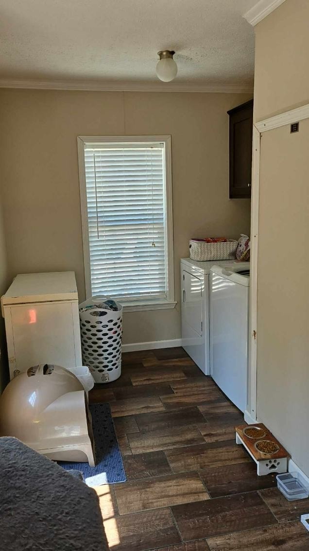 laundry area with crown molding, dark hardwood / wood-style flooring, cabinets, and separate washer and dryer