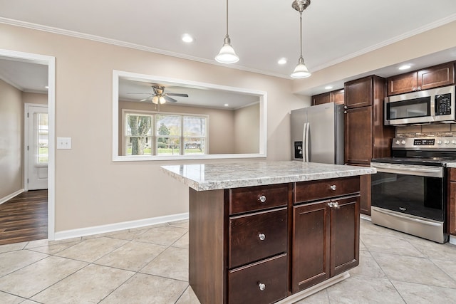 kitchen featuring a center island, stainless steel appliances, crown molding, pendant lighting, and dark brown cabinets