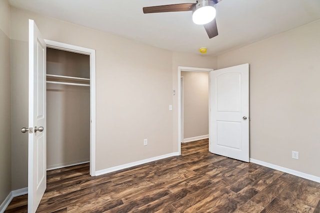 unfurnished bedroom featuring ceiling fan, a closet, and dark wood-type flooring