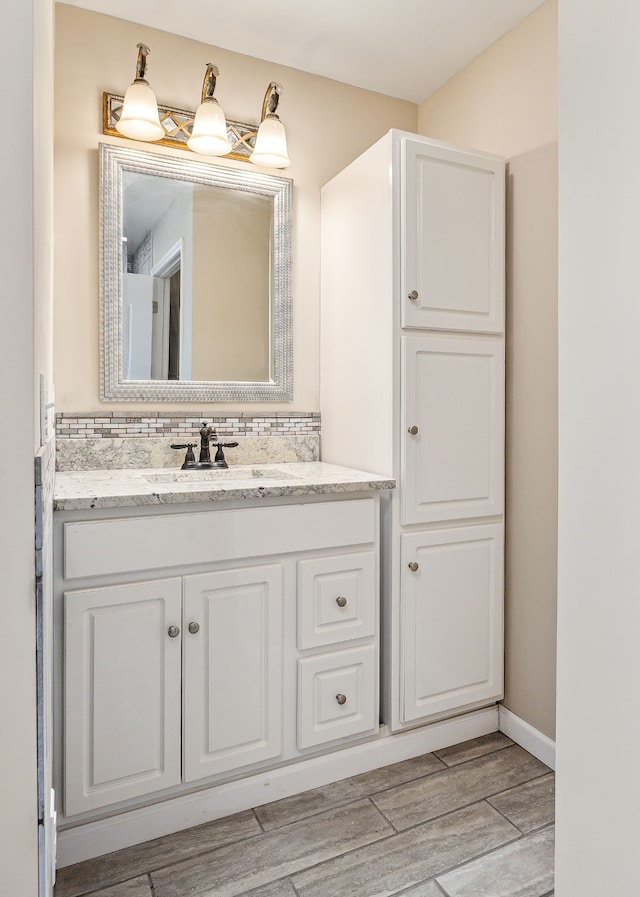 bathroom featuring decorative backsplash, hardwood / wood-style floors, and vanity