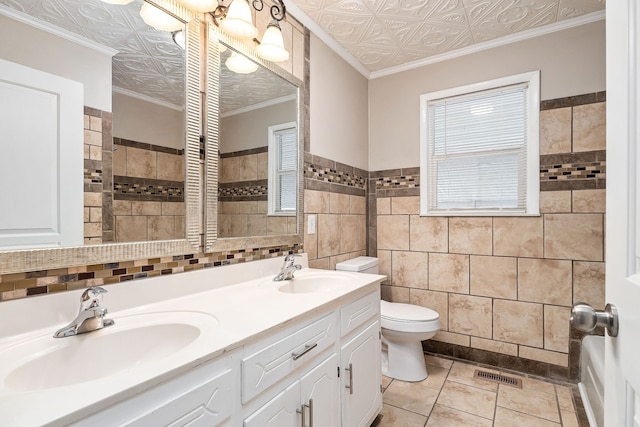 bathroom featuring crown molding, vanity, and tile walls