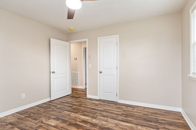 unfurnished bedroom featuring ceiling fan and dark wood-type flooring