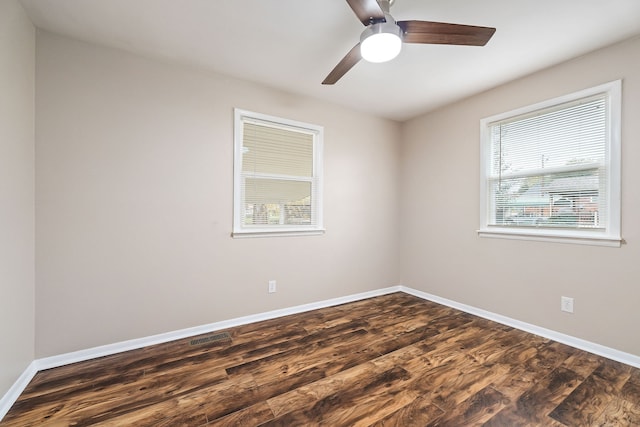 empty room with ceiling fan and dark hardwood / wood-style flooring