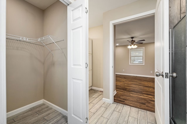 walk in closet featuring ceiling fan and light hardwood / wood-style floors