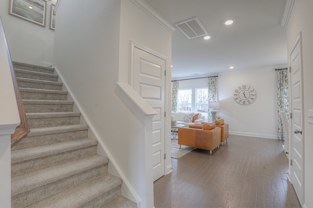 stairway featuring crown molding and hardwood / wood-style floors