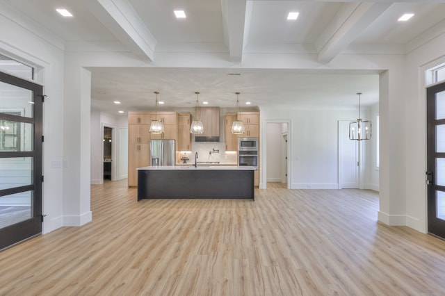 kitchen featuring a spacious island, light wood-type flooring, beamed ceiling, and appliances with stainless steel finishes