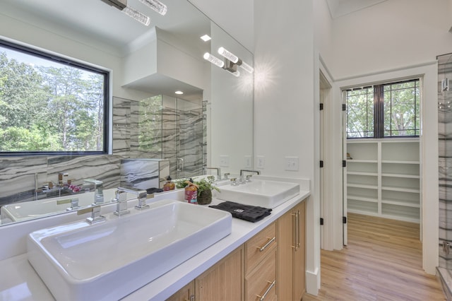 bathroom with vanity, a wealth of natural light, wood-type flooring, and a shower with door