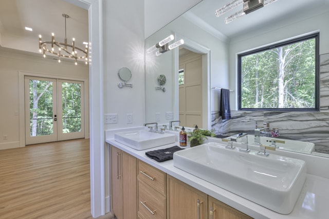 bathroom with vanity, french doors, tile walls, a chandelier, and hardwood / wood-style flooring