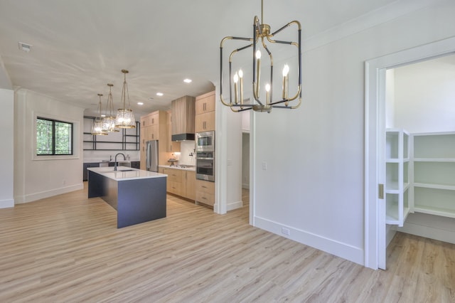 kitchen featuring decorative light fixtures, appliances with stainless steel finishes, sink, light brown cabinets, and light wood-type flooring