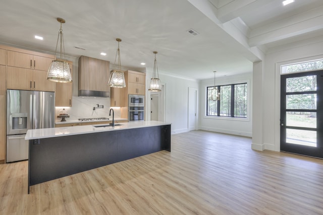 kitchen featuring light hardwood / wood-style flooring, stainless steel appliances, sink, wall chimney exhaust hood, and a center island with sink