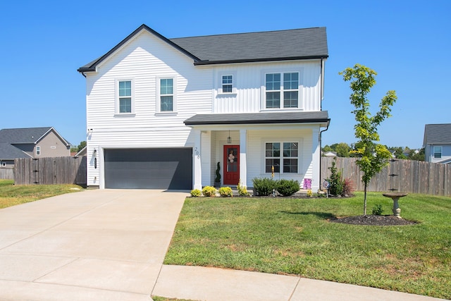 view of front of house featuring a front yard, a porch, and a garage