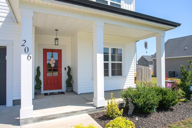 view of exterior entry with covered porch and central air condition unit