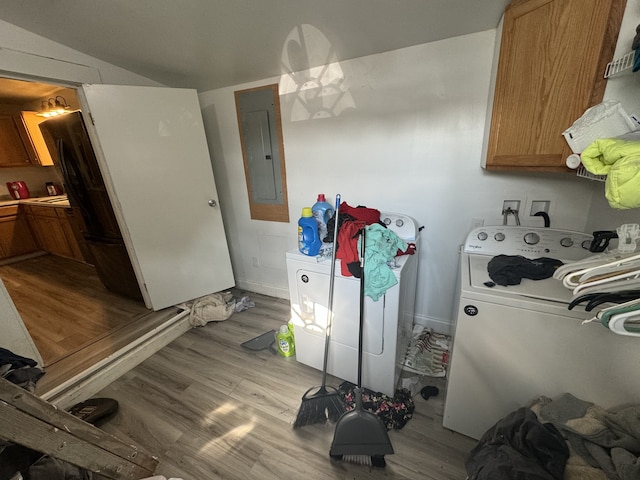 kitchen featuring electric panel, washing machine and dryer, and light wood-type flooring