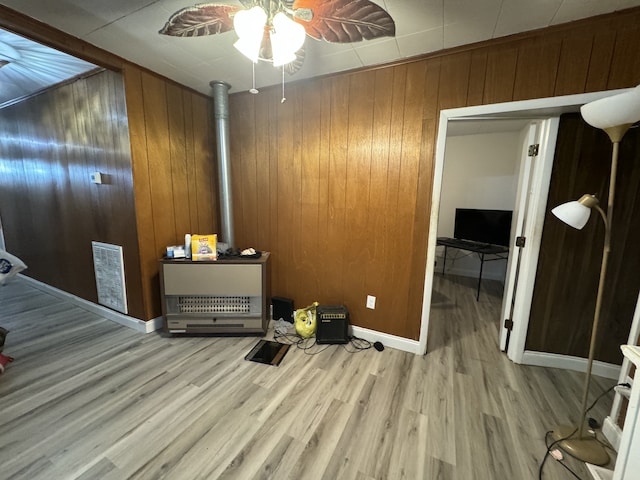 bedroom featuring ceiling fan, hardwood / wood-style floors, and wooden walls