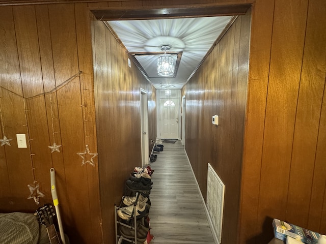 hallway with hardwood / wood-style floors and wooden walls