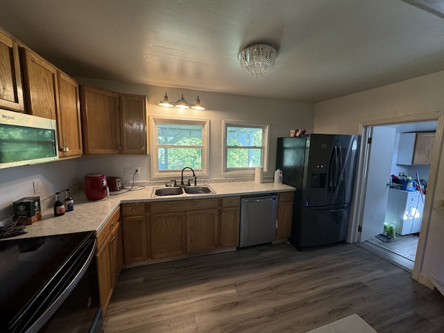 kitchen with black appliances, wood-type flooring, and sink