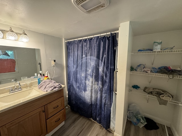 bathroom with a shower with shower curtain, hardwood / wood-style flooring, and vanity