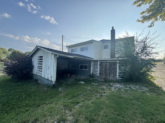 rear view of house featuring a yard