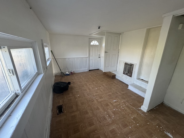 unfurnished living room with dark parquet flooring and heating unit