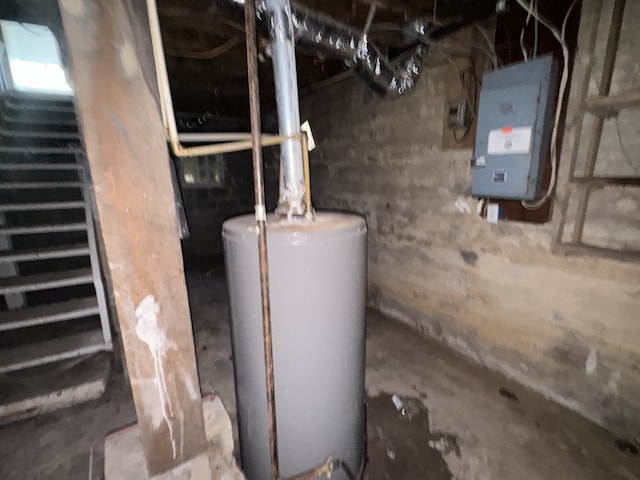 utility room featuring electric panel and water heater