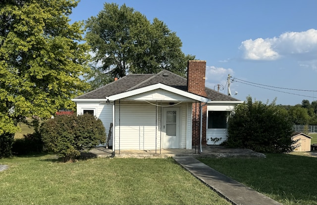 view of front of property featuring a storage shed and a front yard