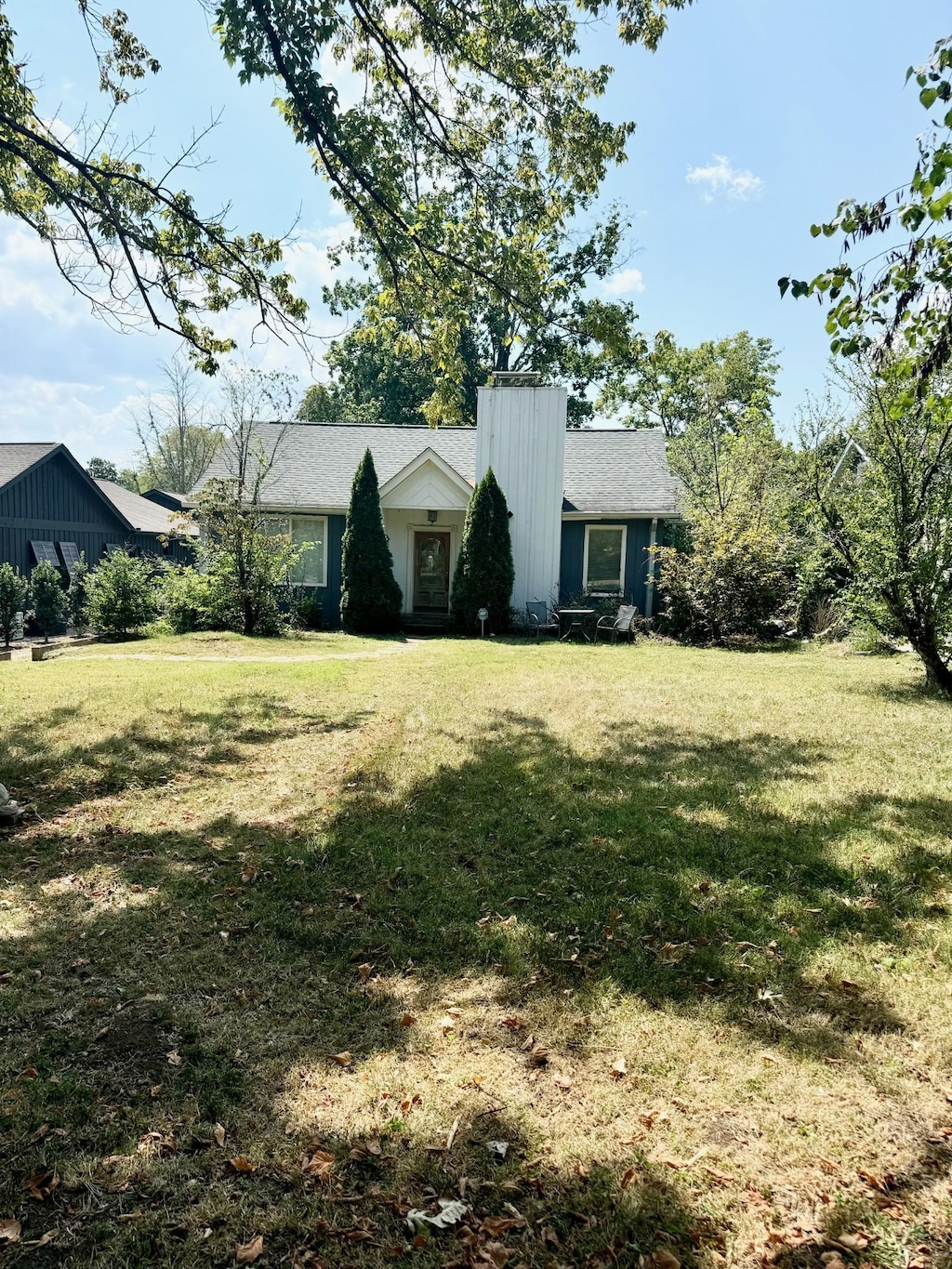 view of front facade featuring a chimney and a front yard