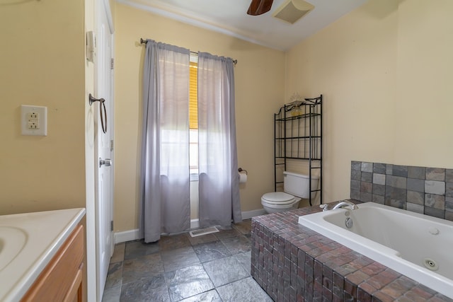 bathroom featuring toilet, tile patterned flooring, vanity, a relaxing tiled tub, and ceiling fan