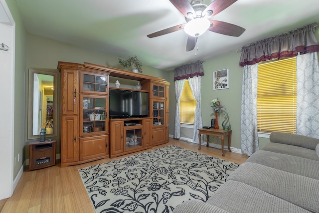 living room with light hardwood / wood-style flooring and ceiling fan