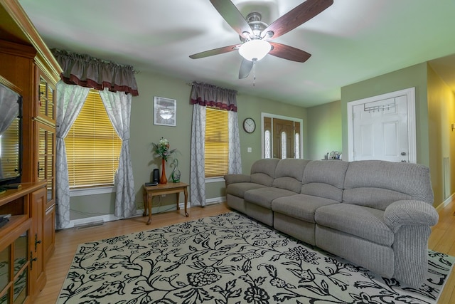 living room featuring light hardwood / wood-style flooring and ceiling fan